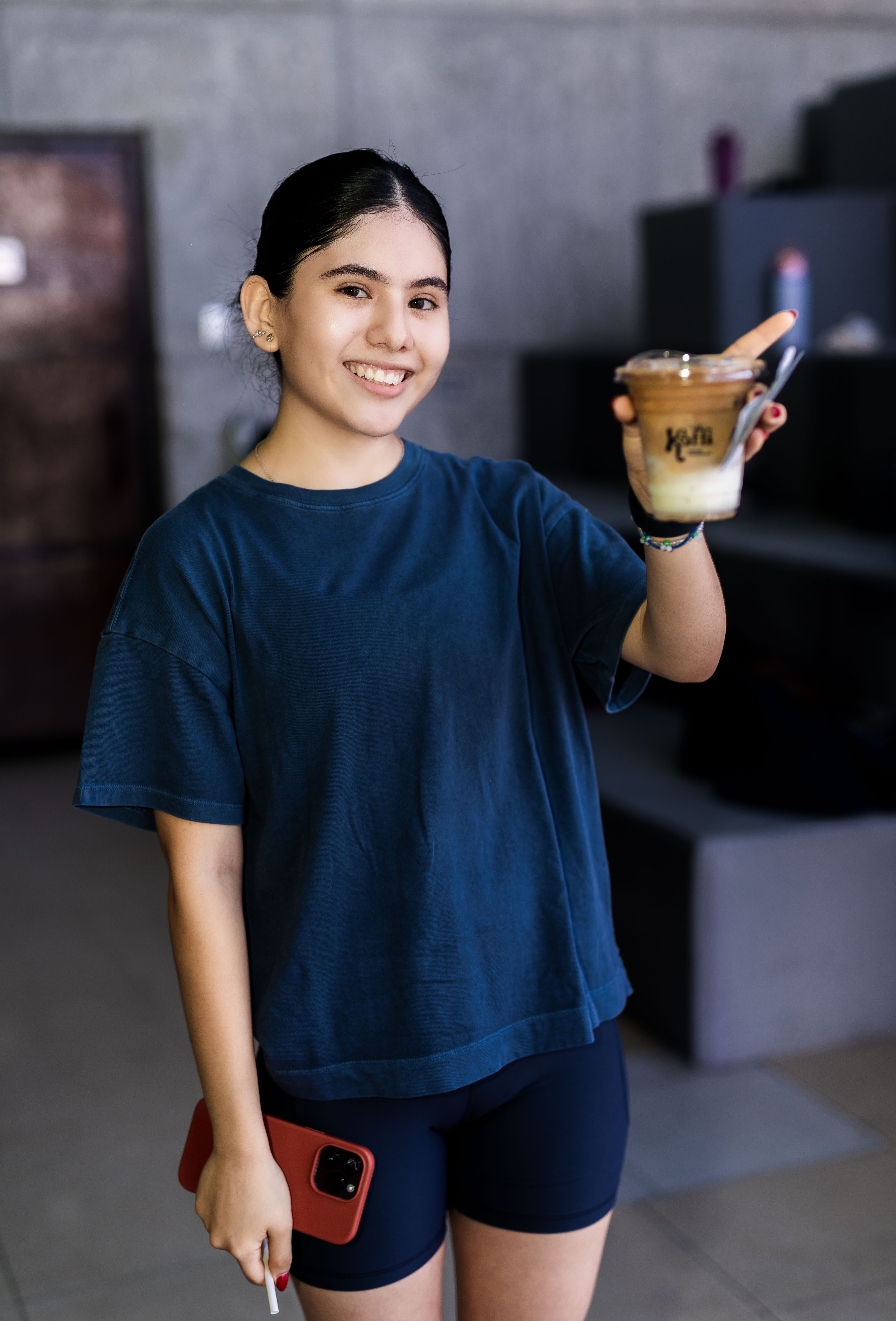 Clienta sonriendo con café Kaffi en evento USPIN